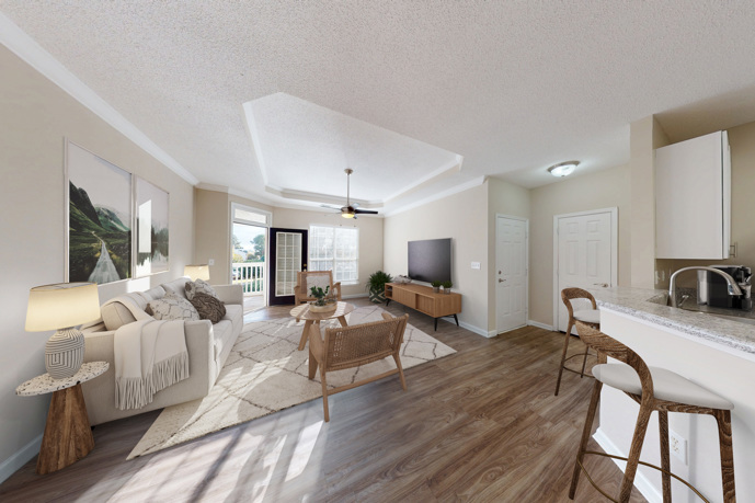 Dining area with a small round glass dining table in front of a white kitchen that has black appliances